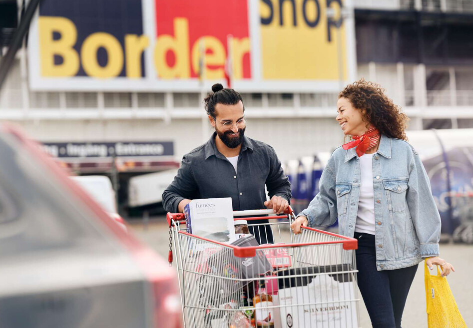 Kunder med fyldt indkøbsvogn foran bordershop